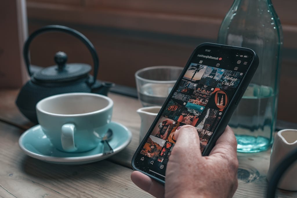 A person scrolling through Instagram feed, an application from Meta, in a coffee shop.